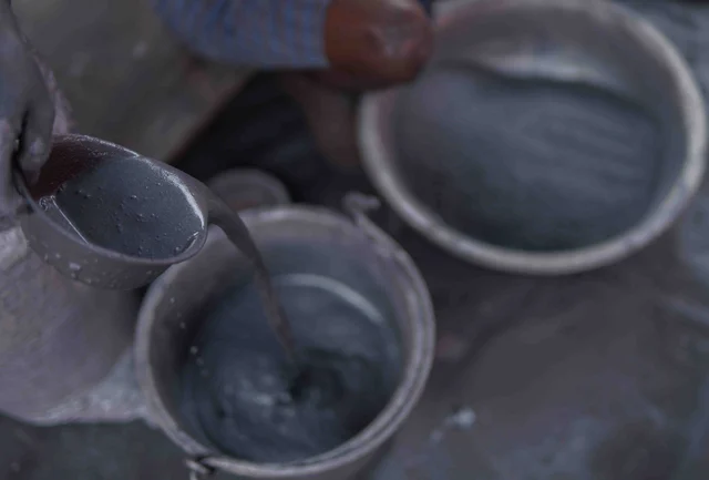 வண்ணம் சிதறாமல் இருப்பதற்காக மருந்தை பிசைய தயாராகிறார்.