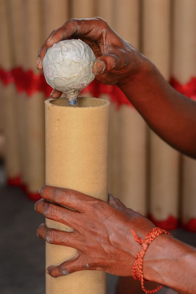 தூக்கு மருந்து போடப்பட்ட குழாயில் வண்ண மணி மருந்துகள் அடங்கிய குடுவை வைக்கப்படுகிறது.
