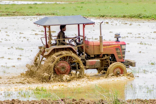 டிராக்டர் மூலம் உழவு செய்யும் விவசாயி.