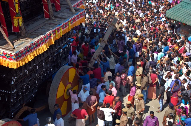 தேர் நகர்ந்து செல்ல தடி போடும் இளைஞர்கள் கூட்டம்.