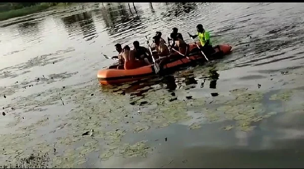 படகு மூலம் குளத்துக்குள் சென்ற போலீஸார்