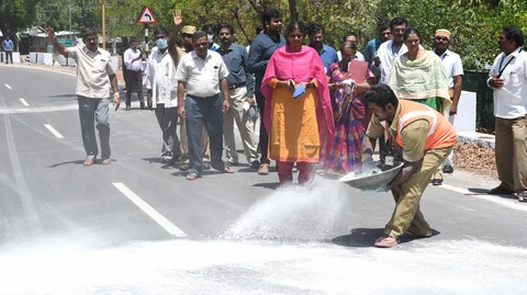 சாலையில் குளோரின் பவுடர் போடப்படுகிறது