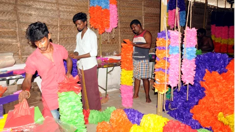 மாலைகள் தயாரிக்கும் பணியில் தொழிலாளர்கள்