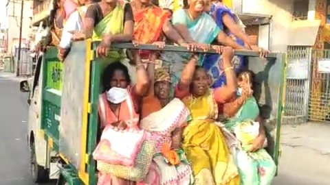 குப்பை வண்டியில் செல்லும் தூய்மைப் பணியாளர்கள்