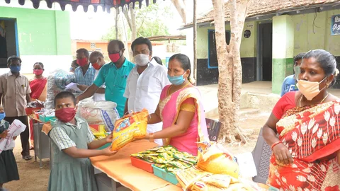 நிவாரண தொகுப்பு பெறும் மாணவி