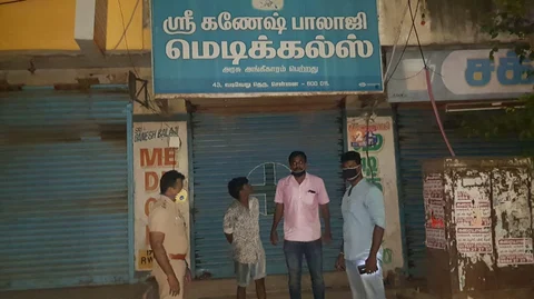 கொள்ளையடித்த கடை முன் மதன் மற்றும் போலீஸார்