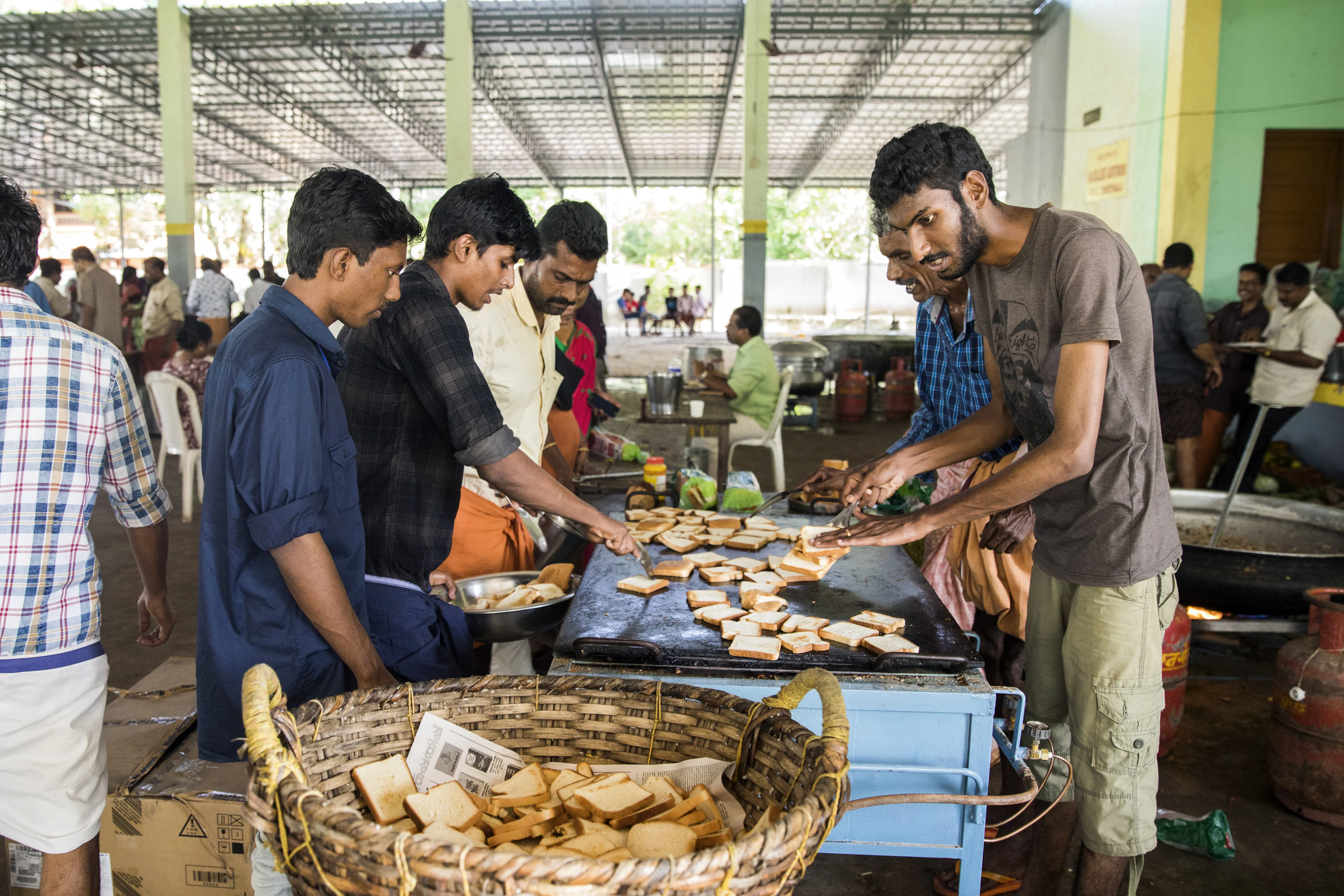 Volunteers prepare and serve food to flood victims in Alappuzha, Kerala, on Aug. 23, 2018. (Photographer: Prashanth Vishwanathan/Bloomberg)