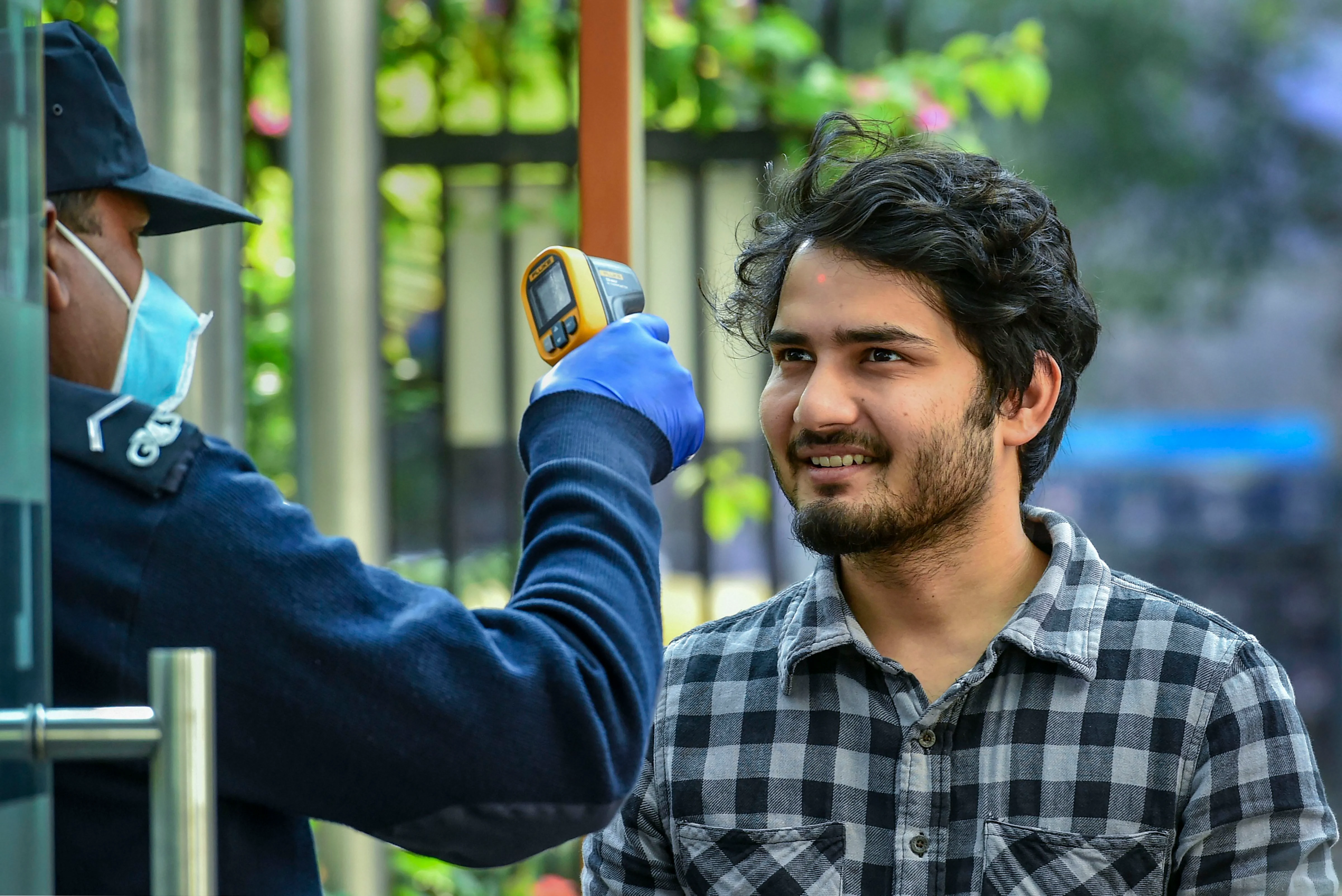 An official uses a thermal screening device on an employee at an office in New Delhi (Source: PTI)