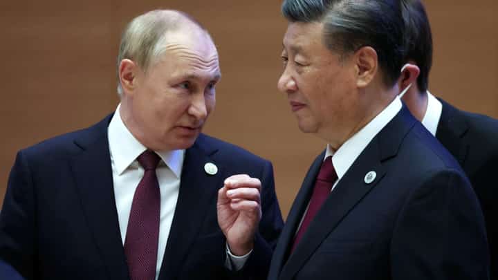 Russian President Vladimir Putin speaks to China's President Xi Jinping during the Shanghai Cooperation Organisation (SCO) leaders' summit in Samarkand on September 16, 2022. Photo by Sergei BOBYLYOV / SPUTNIK / AFP