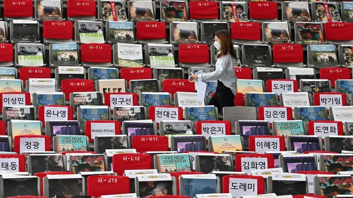 In this file photo, a staff member sets up seats ahead of the opening ceremony for the 26th Busan International Film Festival at the Busan Cinema Center in Busan on 6 October 2021. (Photo by Jung Yeon-je / AFP)