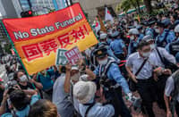 Anti-state funeral protesters demonstrate in a street near the Nippon Budokan ahead of the state funeral for former Japanese prime minister Shinzo Abe in Tokyo on 27 September 2022. (Photo by YUICHI YAMAZAKI / AFP)