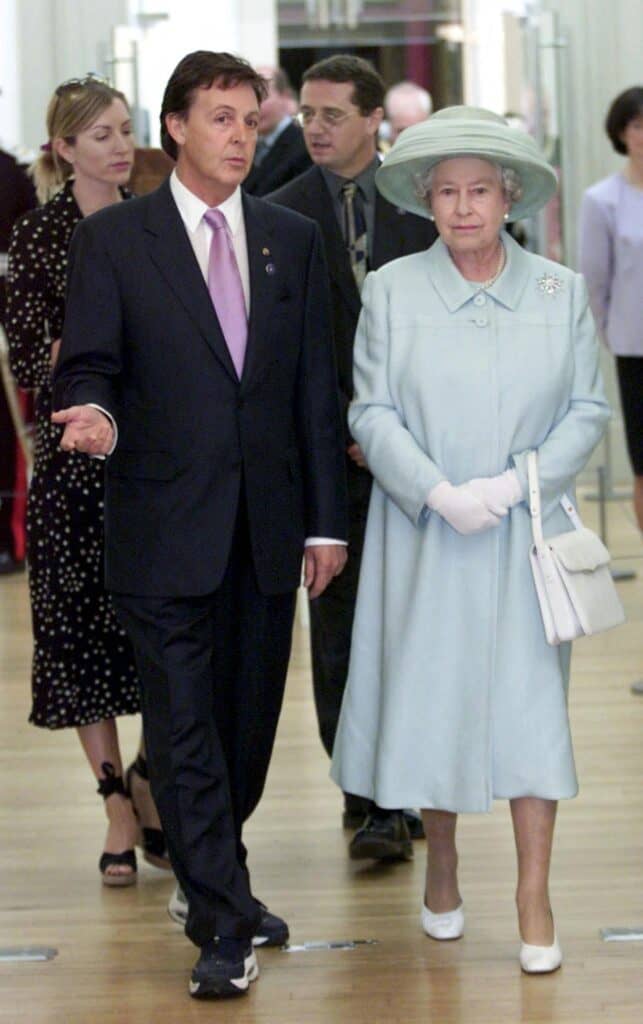 Sir Paul McCartney shows Queen Elizabeth II his paintings during a visit to the Walker Art Gallery in Liverpool, 25 July 2002. | MARC GIDDINGS / POOL / AGENCE FRANCE-PRESSE
