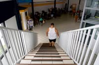 In this file photo, a patient climbs up and down to work on endurance and cardio at the Ora Ora follow-up care and rehabilitation center (Soins de Suite et Readaptation-SSR) for patients with overweight issues or obesity, in Pirae, Tahiti, French Polynesia, on 10 September 2021. Obesity conditions currently cost 2.2 percent of global GDP, and the biggest increases are expected to be seen in lower-resourced countries. (Photo by SULIANE FAVENNEC / AFP)