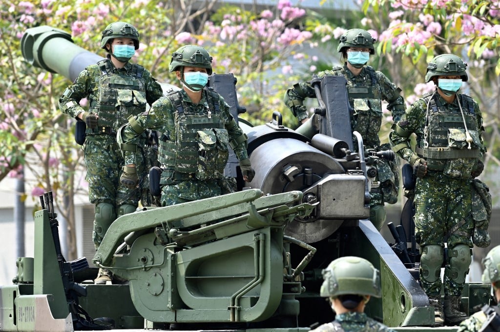 In this file photo taken on 9 April 2020, female soldiers wearing face masks amid the COVID-19 coronavirus pandemic stand in formation on a US-made M110A2 self-propelled howitzer during Taiwan President Tsai Ing-wen's visit to a military base in Tainan, southern Taiwan. The United States on 2 September 2022 announced a new $1.1 billion package of arms to Taiwan, vowing to keep boosting the island's defenses as tensions soar with Beijing. (Photo by SAM YEH / AFP)