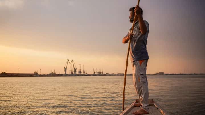 Iraqi fisherman Naim Haddad, 40, stands barefoot on his boat at sunset on Shatt al-Arab, the confluence of the Tigris and Euphrates rivers near the city of Basrah in southern Iraq, on 12 February 2022. The Tigris is one of Iraq's two big rivers that gave birth to the ancient empires of Sumer and Babylonia and are said to have watered the biblical Garden of Eden. Today, it is dying because of human activity and climate change. (Photo by AYMAN HENNA / AFP)
