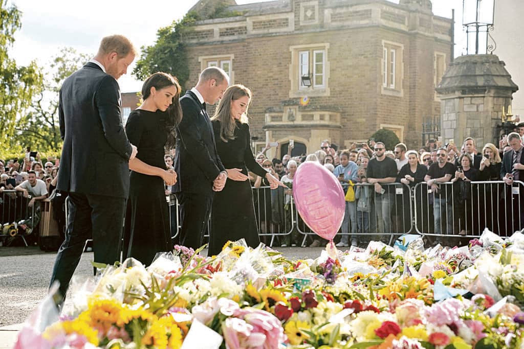 Floral tributes Britain's Prince Harry, Duke of Sussex, (left) his wife Meghan, Duchess of Sussex (second from left), Britain's Prince William, Prince of Wales (second from right) and his wife Britain's Catherine, Princess of Wales, (right) admire the floral tributes laid in memory of Queen Elizabeth II on Saturday. | Kirsty O'Connor / POOL/AGENCE FRANCE-PRESSE