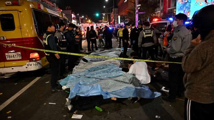 The bodies of victims, believed to have suffered from cardiac arrest, are covered with sheets in the popular nightlife district of Itaewon in Seoul on October 30, 2022. - Dozens of people suffered from cardiac arrest in the South Korean capital Seoul on October 29, after thousands of people crowded into narrow streets in the city's Itaewon neighbourhood to celebrate Halloween, local officials said. (Photo by Jung Yeon-je / AFP)
