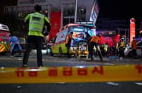 Medical staff attend to a person on a stretcher in the popular nightlife district of Itaewon in Seoul on October 30, 2022. - Dozens of people suffered from cardiac arrest in the South Korean capital Seoul, after thousands of people crowded into narrow streets in the city's Itaewon neighbourhood to celebrate Halloween, local officials said. Photo by JUNG YEON-JE / AFP