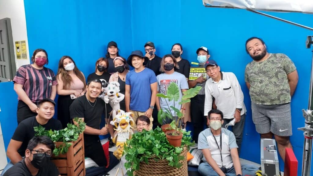 Cast and crew members bond at the Jumpcat studio: (Back row, from left) editor and animator Chris Cordova; production manager Jera Bernadas; associate producer Ishna Salgados; co-directors Froi Fabella and Joan Lopez-Flores, cinematographer Jericho Filomeno; production designer Mariane Paola De Leoz; production design crew Axel Calacday; (middle row) cinematographer Racker Masagca; Bespren Tuts puppeteer Manny Urbano; host Vic Robinson; art director and graphics designer Pat Dizon; hair and makeup stylist Jacobo Balisi, scriptwriter JP Lopez; (front row, seated) puppeteer assistant Kenneth Benedicto; Manang Agi puppeteer Priscilla 'Rose' Nalundasan; and puppeteer assistant Jaymar Nalundasan.