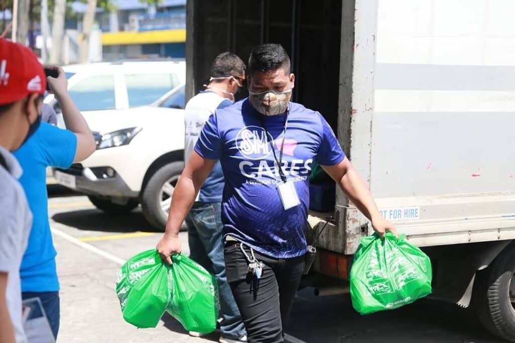 Kalinga Packs distribution: An SM employee volunteer unloads relief packs for families affected by the pandemic. (Photo courtesy of SM Foundation, Inc.)