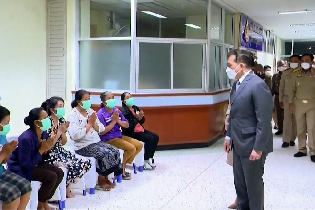 This frame grab from Royal Pool video footage made available via AFPTV on 7 October 2022 shows Thai King Maha Vajiralongkorn (right) meeting with relatives at a hospital in Thailand's Nong Bua Lam Phu, where the monarch met survivors and relatives after a mass shooting by a former police officer at a nursery. (Photo by Royal Pool via AFPTV / AFP)