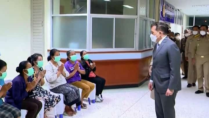 This frame grab from Royal Pool video footage made available via AFPTV on 7 October 2022 shows Thai King Maha Vajiralongkorn (right) meeting with relatives at a hospital in Thailand's Nong Bua Lam Phu, where the monarch met survivors and relatives after a mass shooting by a former police officer at a nursery. (Photo by Royal Pool via AFPTV / AFP)