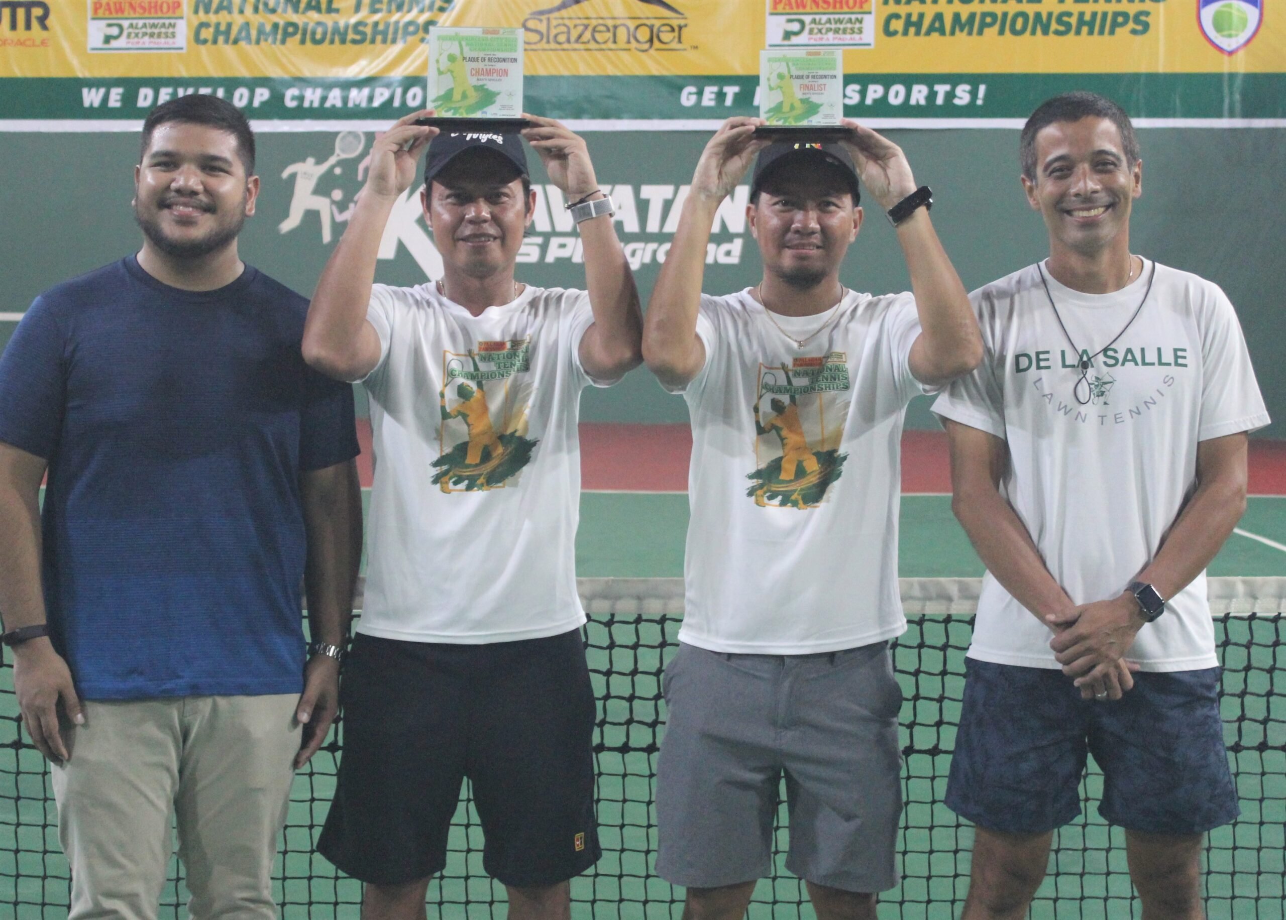 JOHNNY Arcilla (second from left) and Ronard Joven lift their trophies after finishing 1-2 in the Puerto Princesa Open Championship recently. Also shown are PPS-PEPP director Roberto Ben Castro (left) and coach Ronald Kraut. | PHOTOGRAPH COURTESY OF JOHNNY Arcilla