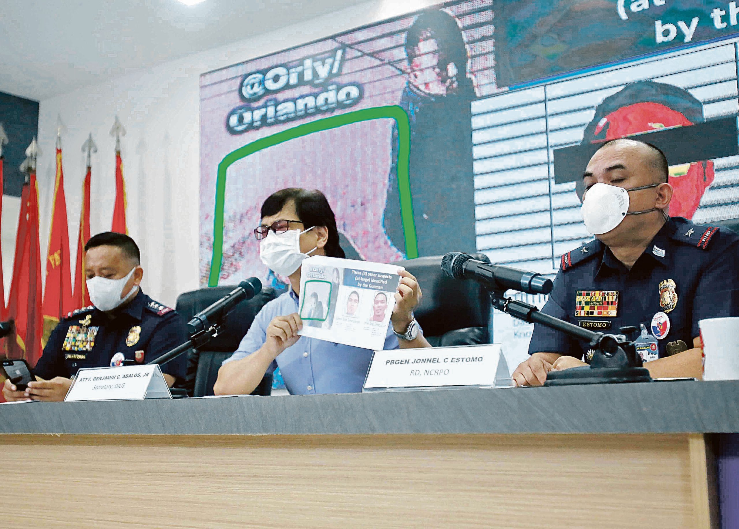 Interior Secretary Benhur Abalos Jr. (center) shows the photos of three other suspects at large in the killing of broadcaster Percy Mabasa following the surrender of Joel Salve Estorial. Also in photo are Philippine National Police officer-in-charge P/Lt. Gen. Rhodel Sermonia (left) and National Capital Region Police Office regional director P/Brig. Gen. Jonnel Estomo. PHOTO BY ANALY LABOR FOR THE DAILY TRIBUNE @tribunephl_ana/FILE.