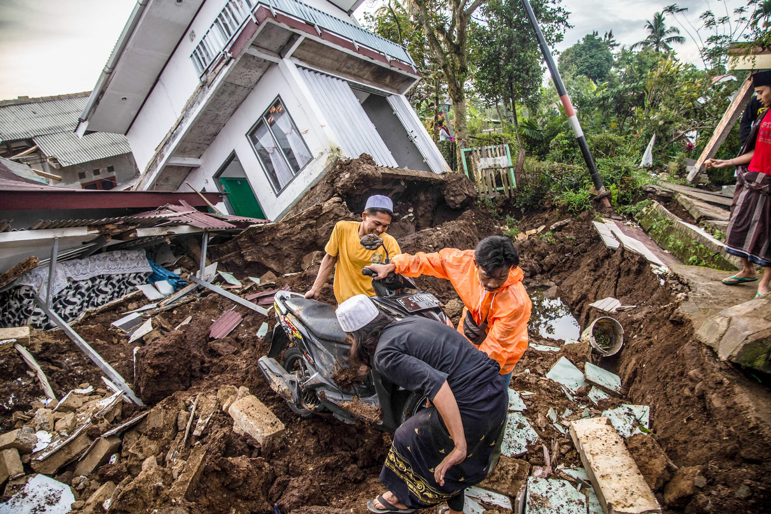 Villagers salvage items from damaged houses following a 5.6-magnitude earthquake that killed at least 162 people, with hundreds injured and others missing in Cianjur on November 22, 2022. (Photo by ADITYA AJI / AFP)