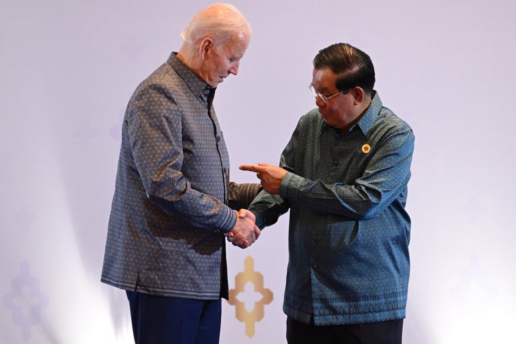 US President Joe Biden (left) and Cambodia's Prime Minister Hun Sen shake hands as they attend the East Asia Summit Gala dinner in Phnom Penh, on 12 November 2022. The Cambodian leader said in a Facebook post he returned a positive result on arrival in Indonesia for a G20 summit but was not experiencing any symptoms. (Photo by SAUL LOEB / AFP)