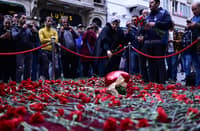 People lay flowers at a makeshift memorial for the victims of the 13 November explosion at the busy shopping street of Istiklal in Istanbul on 14 November 2022. (Photo by YASIN AKGUL / AFP)