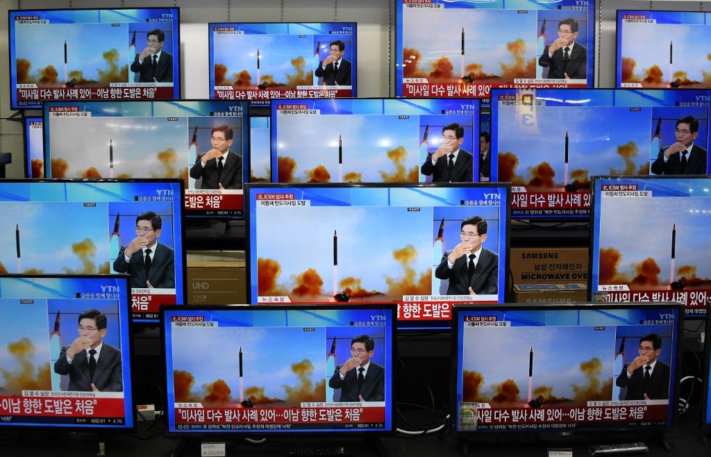 Television screens show a news report about the latest North Korean missile launch with file footage of a North Korean missile test, at an electronic market in Seoul on 3 November 2022. (Photo by JUNG YEON-JE / AFP)
