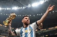 LIONEL Messi displays the trophy after leading Argentina to a dramatic penalty shootout victory over France in the final of the World Cup. Photo by Anne-Christine POUJOULAT / AFP