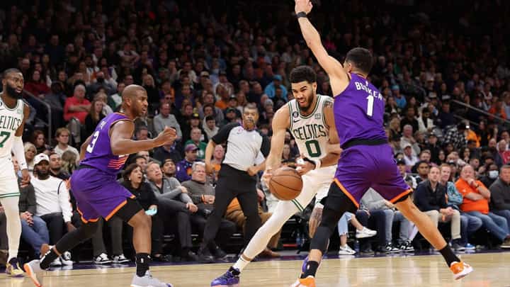 Jayson Tatum of the Boston Celtics drives the ball against Devin Booker of the Phoenix Suns during the first half of the NBA game at Footprint Center. Photo by Christian Petersen / GETTY IMAGES NORTH AMERICA / Getty Images via AFP