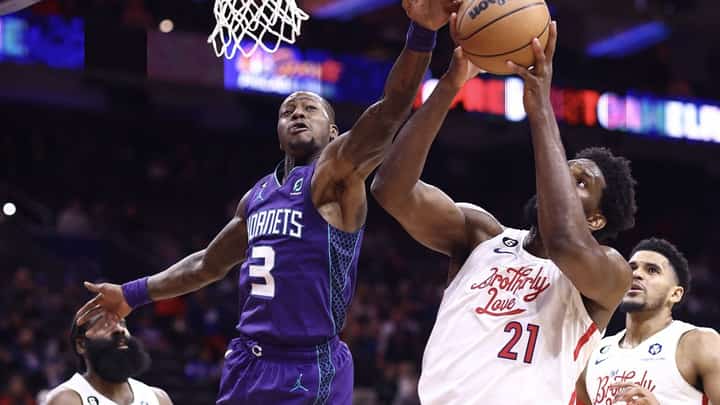 Terry Rozier of the Charlotte Hornets and Joel Embiid of the Philadelphia 76ers reach for a rebound during the fourth quarter at Wells Fargo Center. Photo by Tim Nwachukwu / GETTY IMAGES NORTH AMERICA / Getty Images via AFP