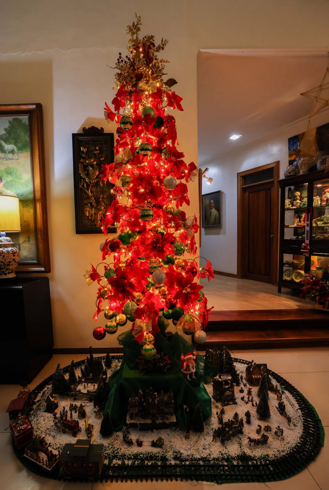 This bright red slim metal Christmas tree stands impressively tall beside the entrance to the family quarters
