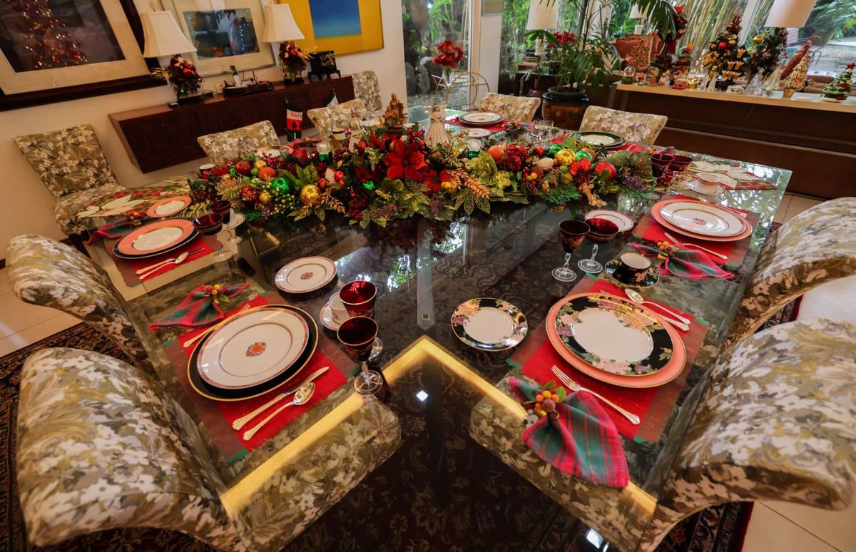 The Jacintos' square formal dining table is a masterpiece of yuletide red and green elegance and gaiety