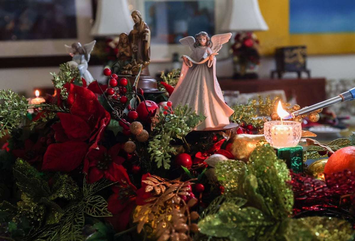 A pair of angels sings on top of a centerpiece manger wreath