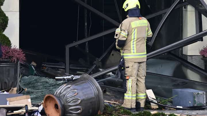 A firefighter stands amid debris in front of the Radisson Blu hotel after a huge aquarium located in the hotel's lobby burst on 16 December 2022 in Berlin. (Photo by JOHN MACDOUGALL / AFP)