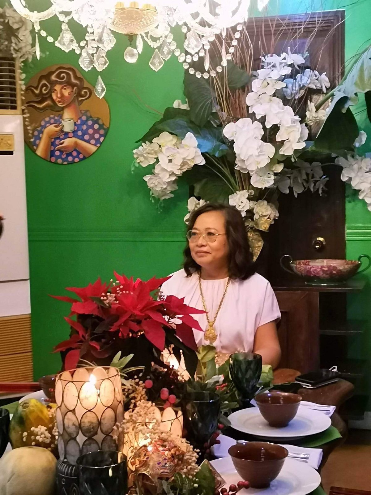 Gemma seated at the kabisera of the dining room.