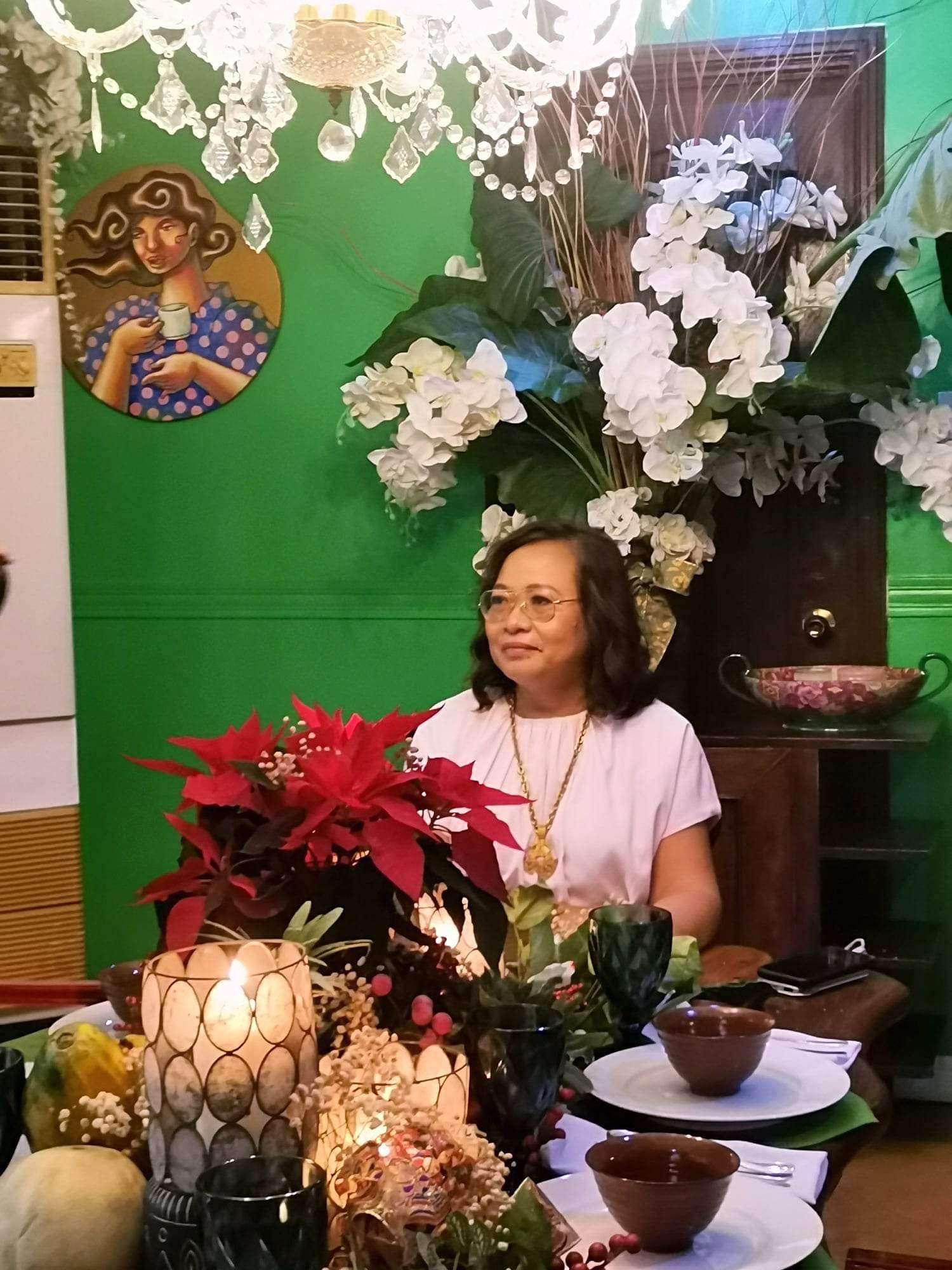Gemma seated at the kabisera of the dining room.