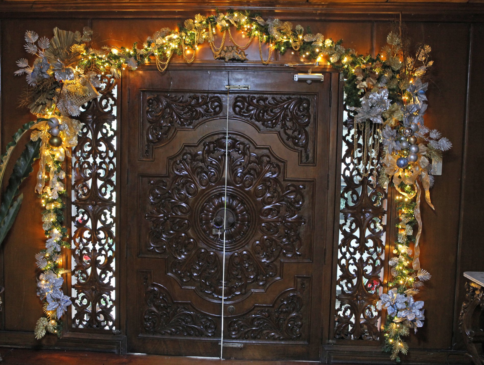 AN antique door is framed by a Christmas wreath.
