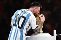 Argentina's forward #10 Lionel Messi holds the Golden Ball award for best player as he kisses the FIFA World Cup Trophy during the trophy ceremony at the end of the Qatar 2022 World Cup final football match between Argentina and France at Lusail Stadium in Lusail, north of Doha on 18 December 12022. (Photo by ANNE-CHRISTINE POUJOULAT / AFP)