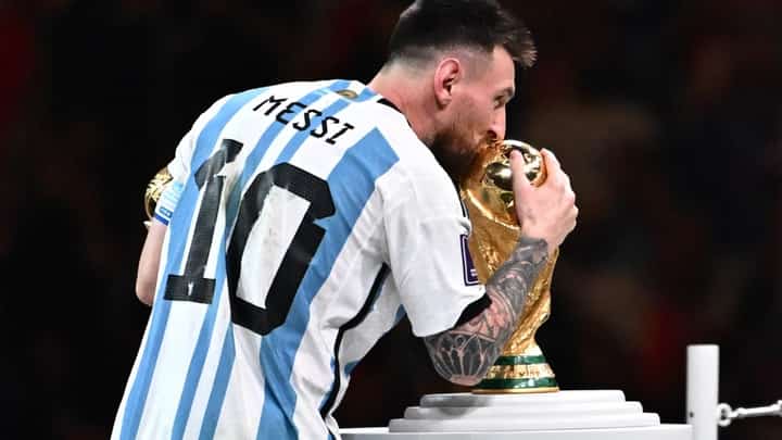 Argentina's forward #10 Lionel Messi holds the Golden Ball award for best player as he kisses the FIFA World Cup Trophy during the trophy ceremony at the end of the Qatar 2022 World Cup final football match between Argentina and France at Lusail Stadium in Lusail, north of Doha on 18 December 12022. (Photo by ANNE-CHRISTINE POUJOULAT / AFP)