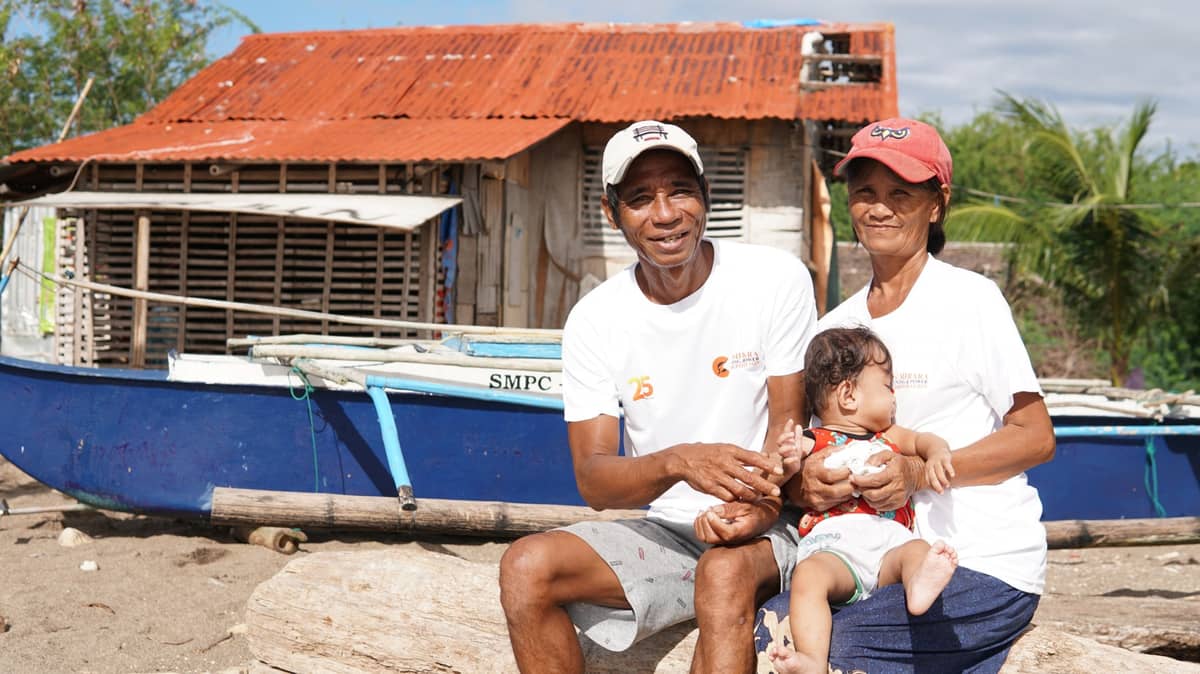 Gonzago Magan, a beneficiary from Barangay Tinogboc, with his wife and grandchild.