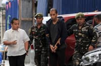 This file photo taken on 24 January 2018 shows Abdelhakim Labidi Adib (center) being escorted by Philippine soldiers as he arrives at the Department of Justice building in Manila. A Spanish national Adib has been convicted on small arms possession nearly five years after his arrest, the Filipino justice department said
on 22 December 2022. (Photo by AFP)