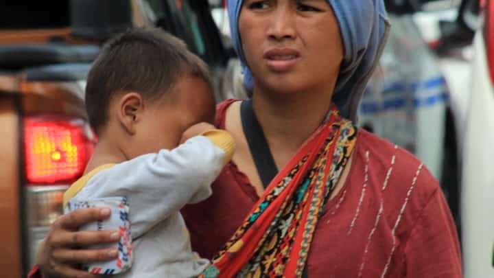 (FILE PHOTO) WITH a baby in tow, this Badjao woman begs for alms on roadsides unmindful of the risks.