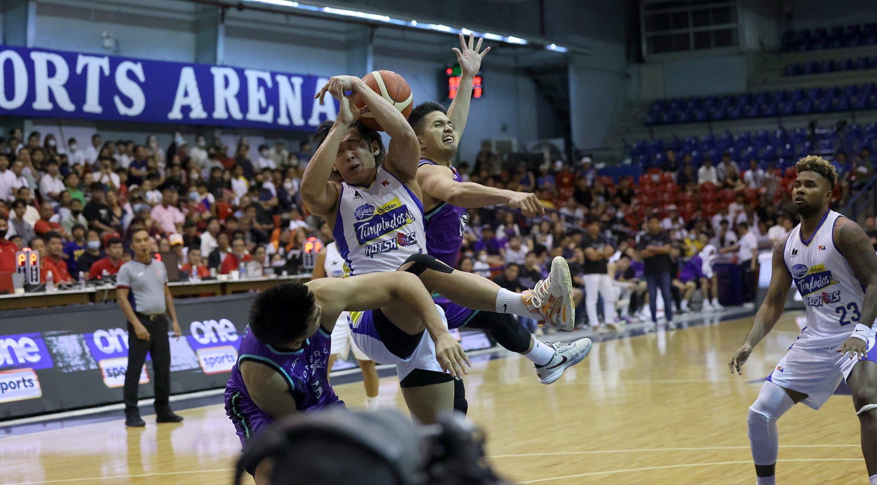 Jackson Corpuz of Magnolia gets clobbered by the defense of Kevin Racal and Jeron Teng of Converge.