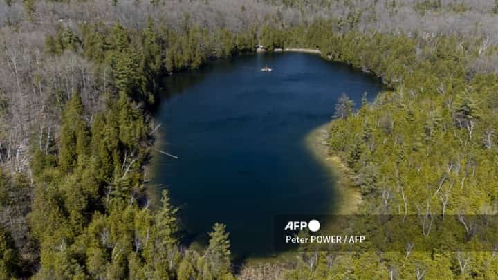 FILE PHOTO: An aerial view of Crawford Lake as a team consisting of scientists from Carleton University and Brock University gather sediment layer samples from the lake bottom at the Crawford Lake Conservation Area near Milton, Ontario, Canada, 12 April 2023. (Photo by Peter POWER / AFP)