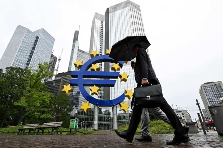 FILE PHOTO: A man shelters from the rain under an umbrella as he walks past the Euro currency sign in front of the former European Central Bank (ECB) building in Frankfurt am Main, western Germany, on 27 July 2023 ahead of thr ECB's monthly announcement on eurozone monetary policy. (Photo by Kirill KUDRYAVTSEV / AFP)